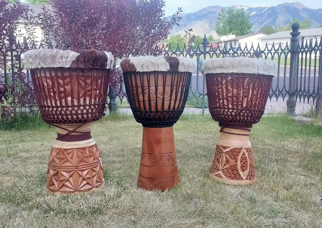 Three of Justin’s finished djembes with different carving and ropework