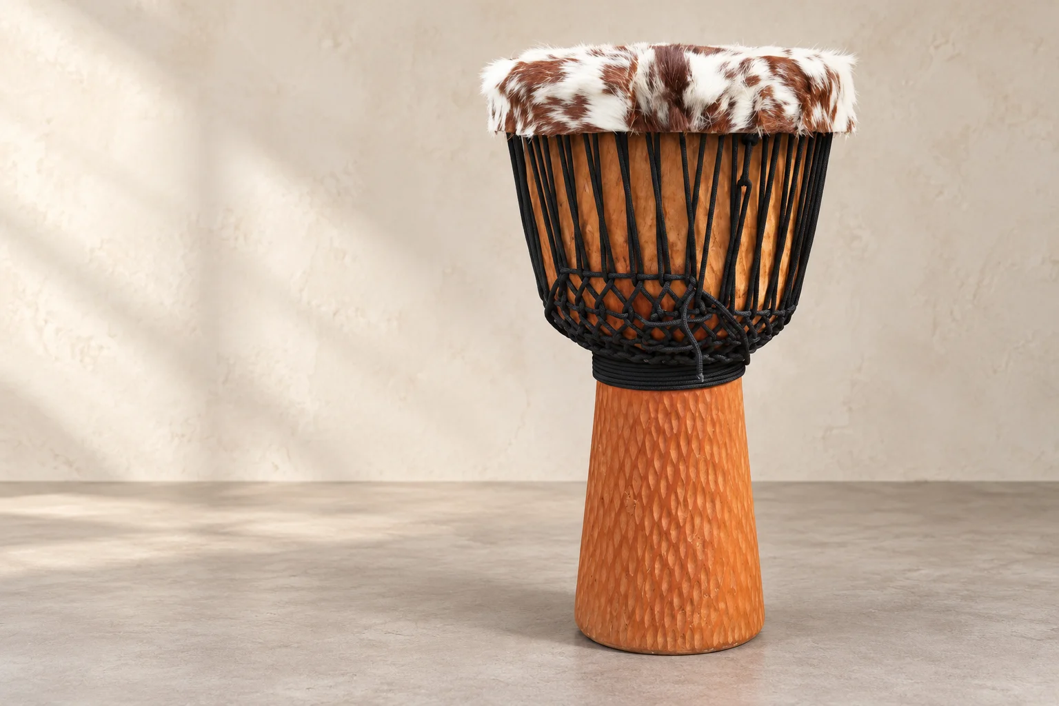 Warm wood djembe with black rope and a brown-and-white hide rim