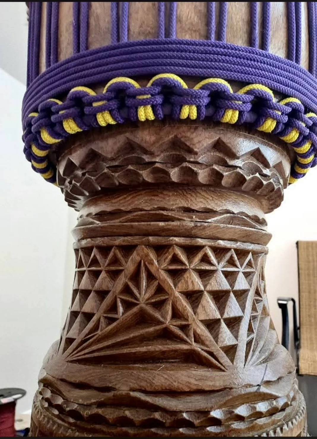 Purple and yellow ropework above hand-carved wooden patterns