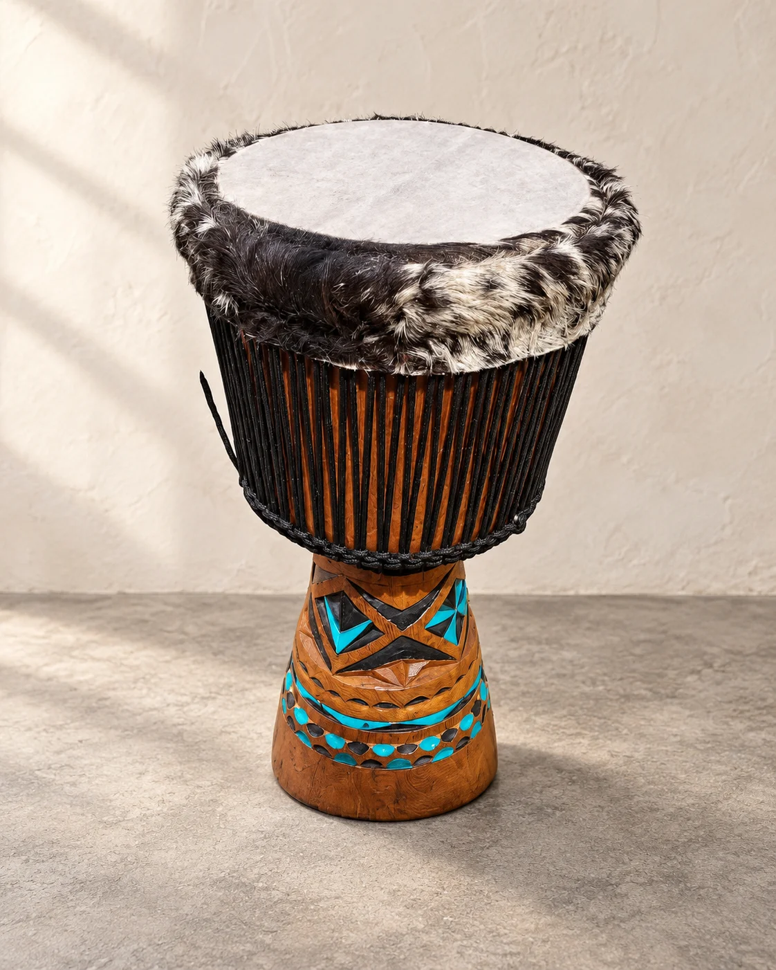 Djembe with black rope and turquoise and dark geometric carving on its base